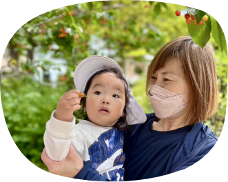 さくらんぼを持つ子どもと保育士